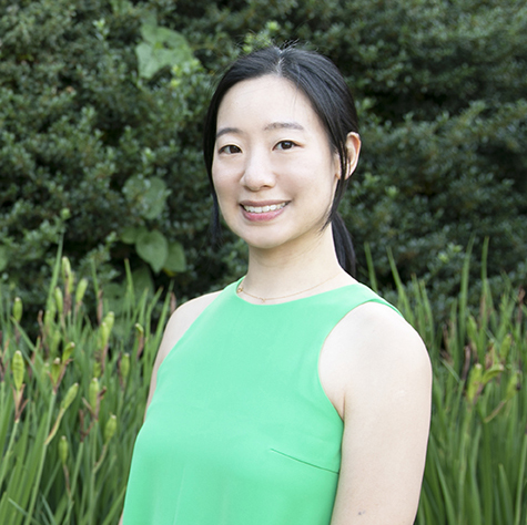 A headshot of Yeseul in a green tank top with a greenery background